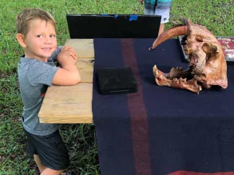 a boy sitting at a table with a large crab on it