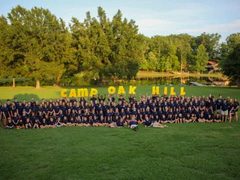 a large group of people posing for a photo in front of a sign