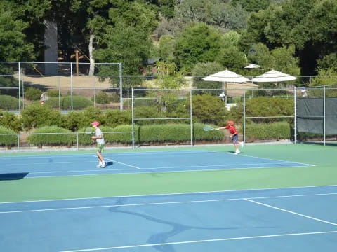 a couple of people play tennis