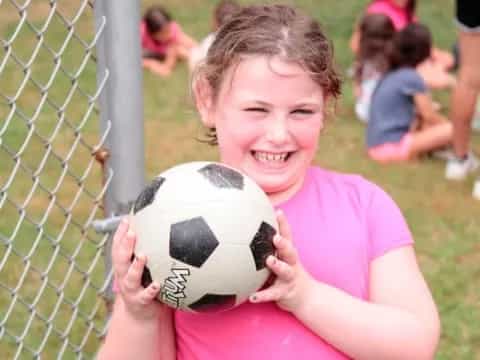 a girl holding a football ball