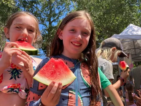 a group of girls eating watermelon