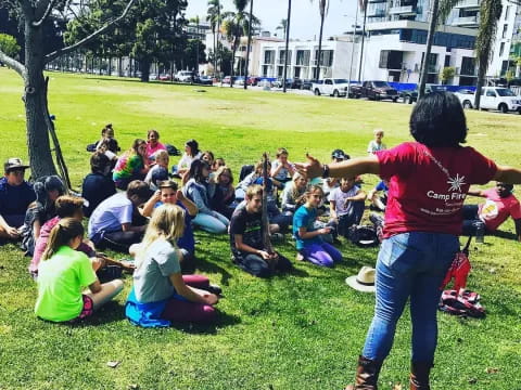 a group of people sitting on the grass