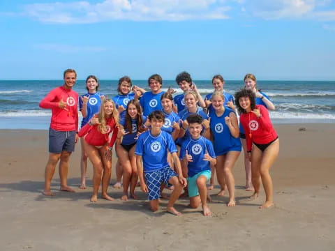 a group of people posing on a beach
