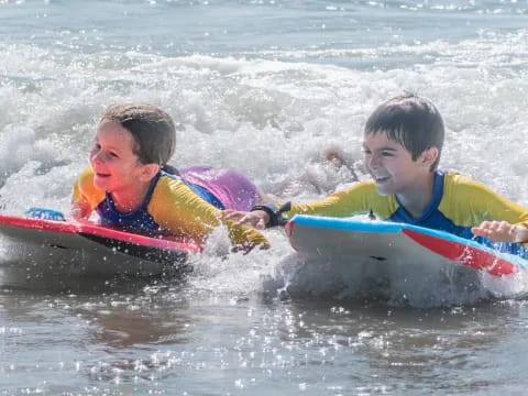 a couple of kids ride on a surfboard