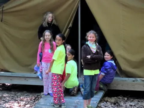 a group of people posing for a photo under a tent