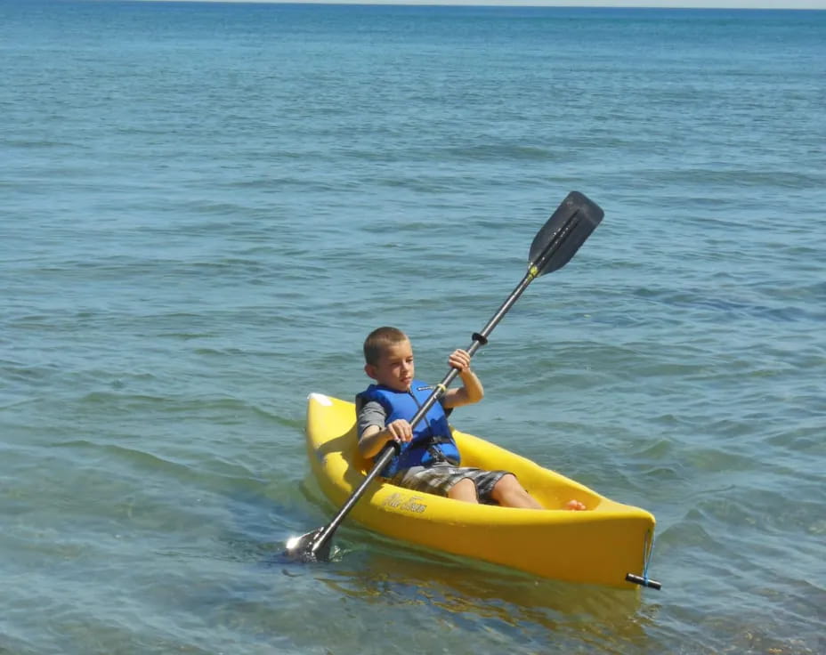 a boy in a yellow kayak