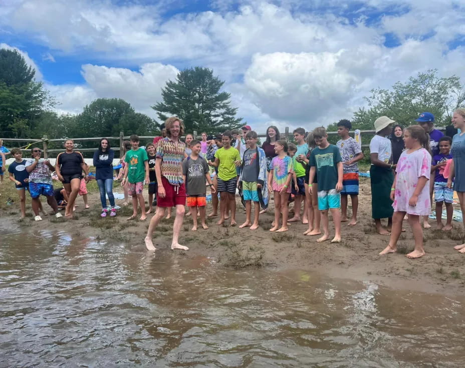 a group of people standing in a muddy area