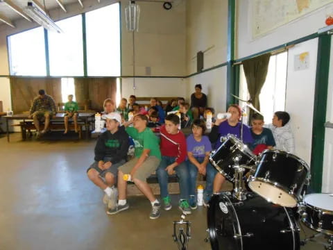 a group of people sitting in a room with drums