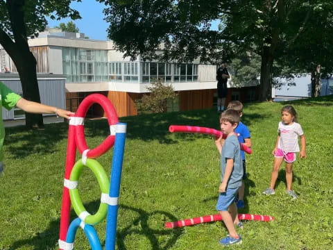 a group of children playing in a yard with a building in the background