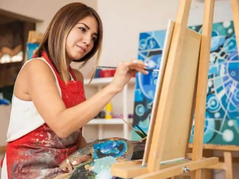 a woman painting on a easel