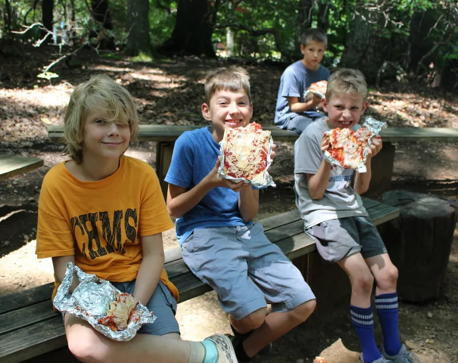 a group of kids eating pizza