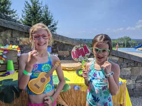 a couple of girls wearing sunglasses and holding up a sign