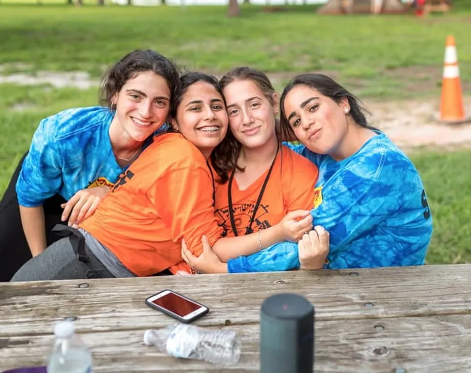 a group of women sitting at a table outside