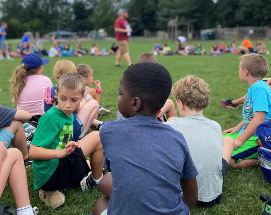 a group of children sitting on the grass