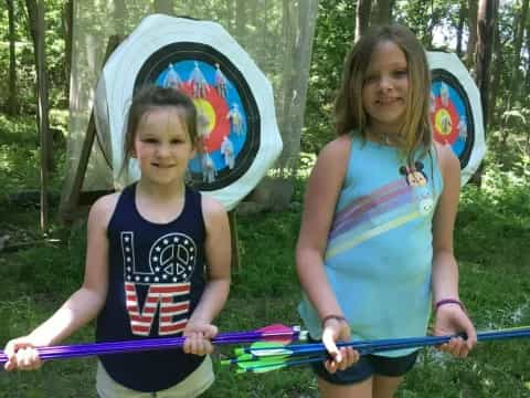 two girls holding bows and arrows