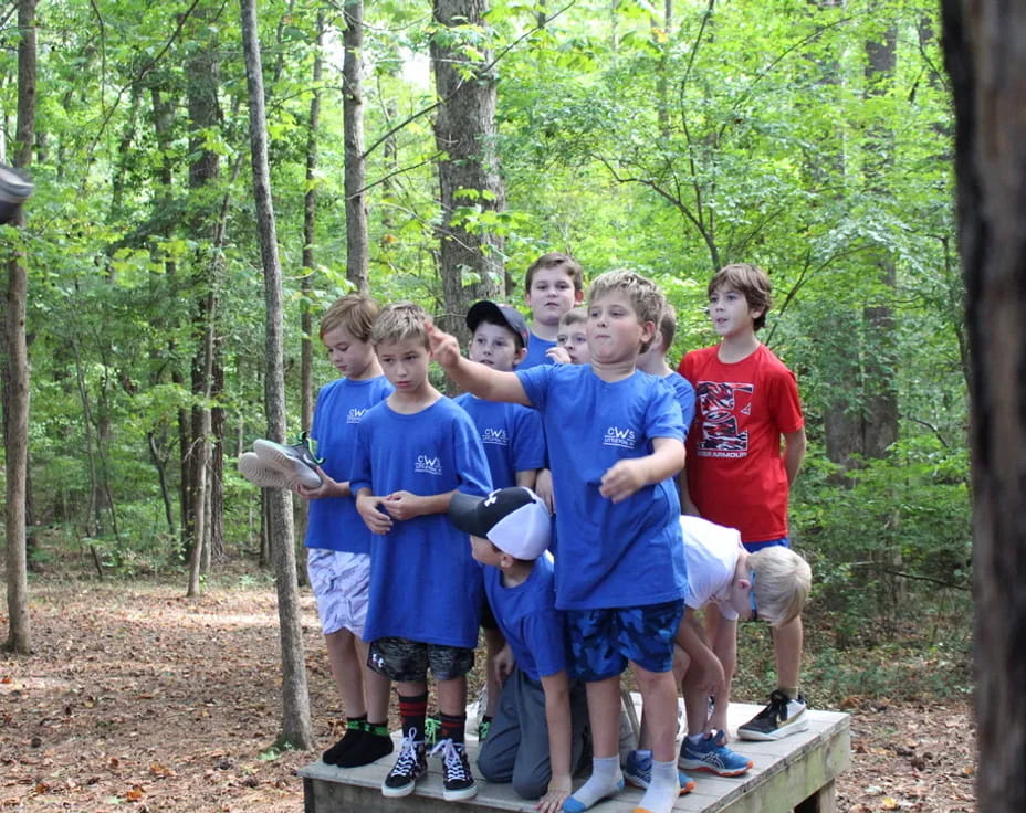 a group of boys standing in the woods