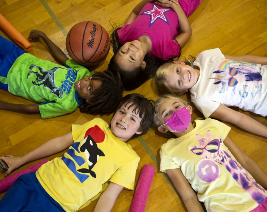 a group of kids lying on the floor with a basketball