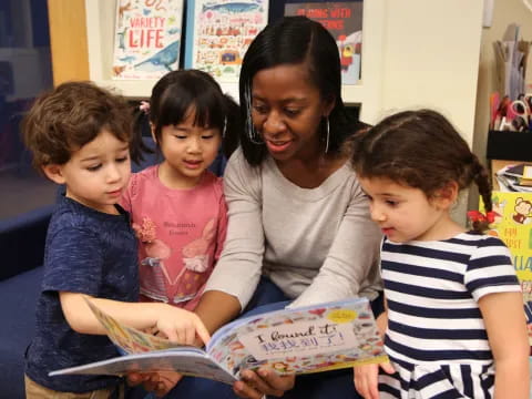 a person reading a book to several children