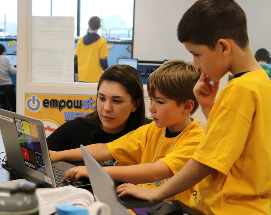 a group of people looking at a laptop