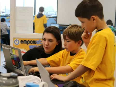 a group of people looking at a laptop