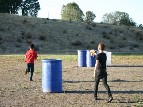 a couple of boys playing with blue barrels