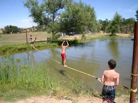 a group of kids playing in a pond