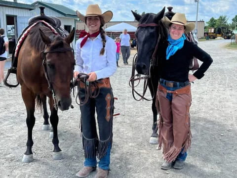 a couple of people stand near some horses