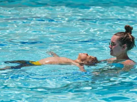 a person and a child swimming in a pool