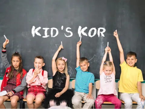 a group of children sitting on a blackboard