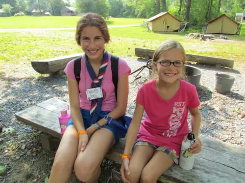 two girls sitting on a bench