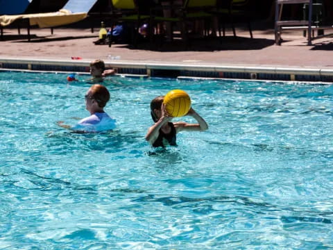 a group of people playing volleyball in a pool