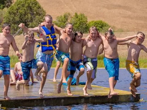 a group of men jumping into a pool