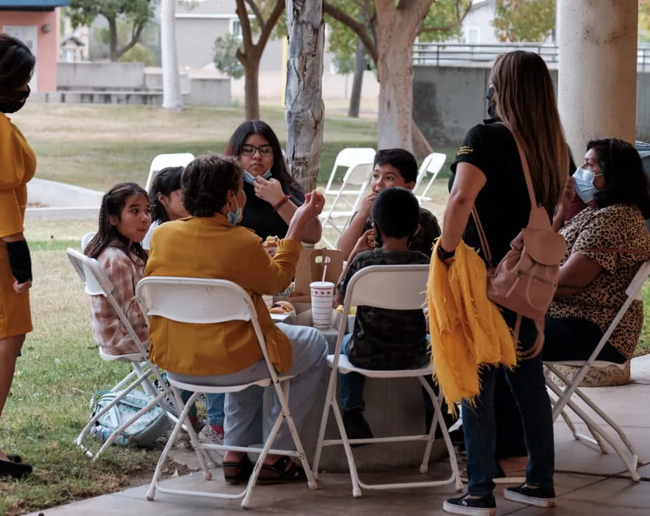 a group of people sitting at a table outside