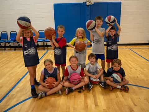 a group of kids posing for a photo with basketballs