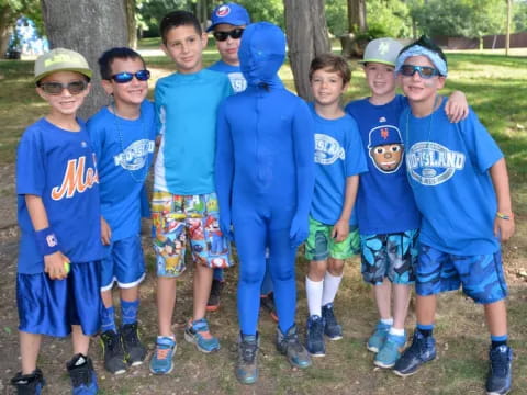 a group of boys wearing matching blue shirts and standing next to each other