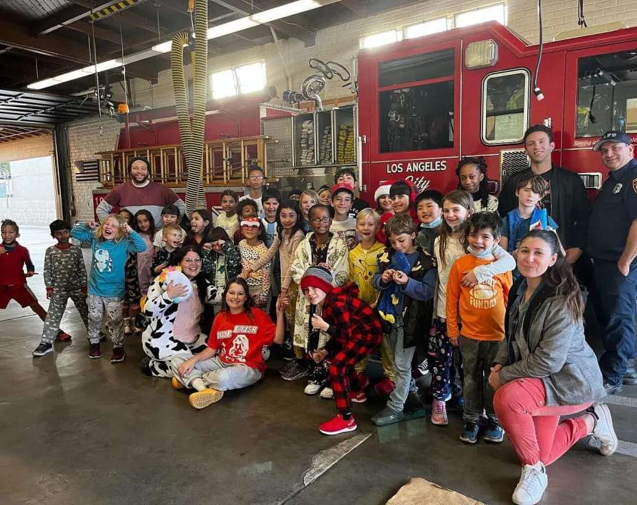 a group of people posing for a photo in front of a firetruck