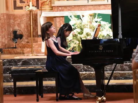 two women kissing in front of a piano