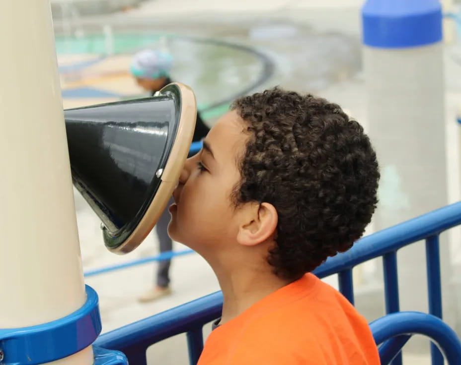 a young boy looking through a microscope