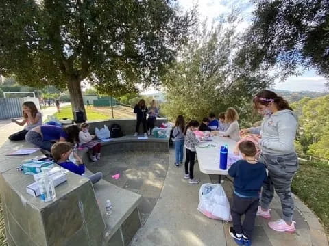 a group of people sitting at tables outside