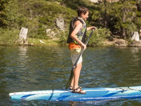 a boy on a paddle board