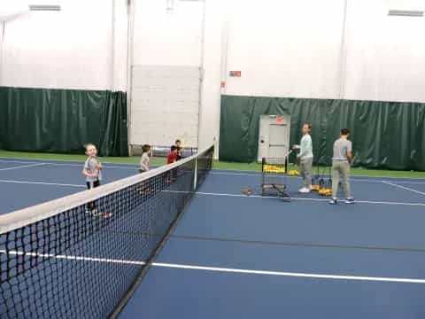 a group of people stand on a tennis court