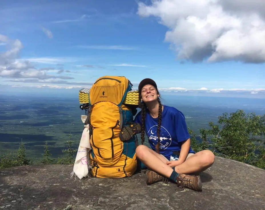 a man sitting next to a backpack