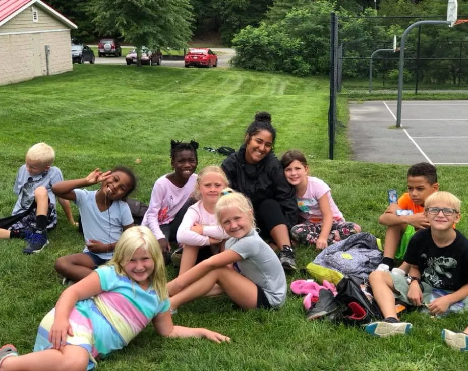 a group of people sitting on the grass