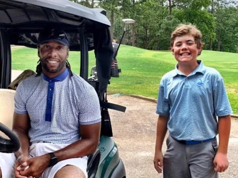 a man and a boy standing next to a golf cart