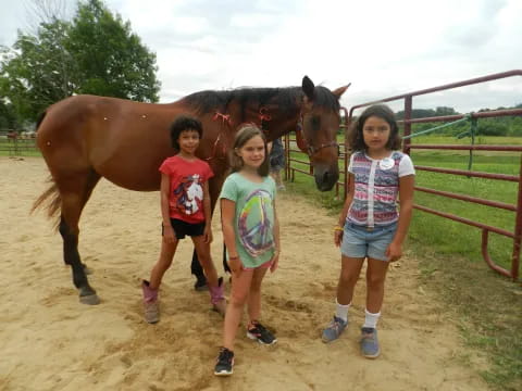 a group of children posing for a photo next to a horse