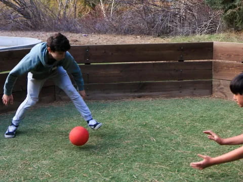 a couple of men playing with a ball in a yard