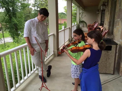 a man playing a violin with a couple of children