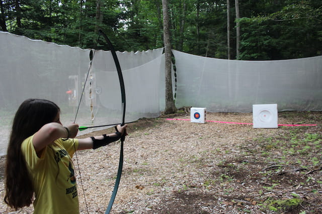 a girl shooting a bow and arrow