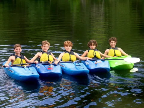 a group of kids in kayaks