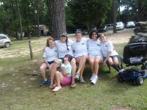 a group of people sitting on a bench in a park